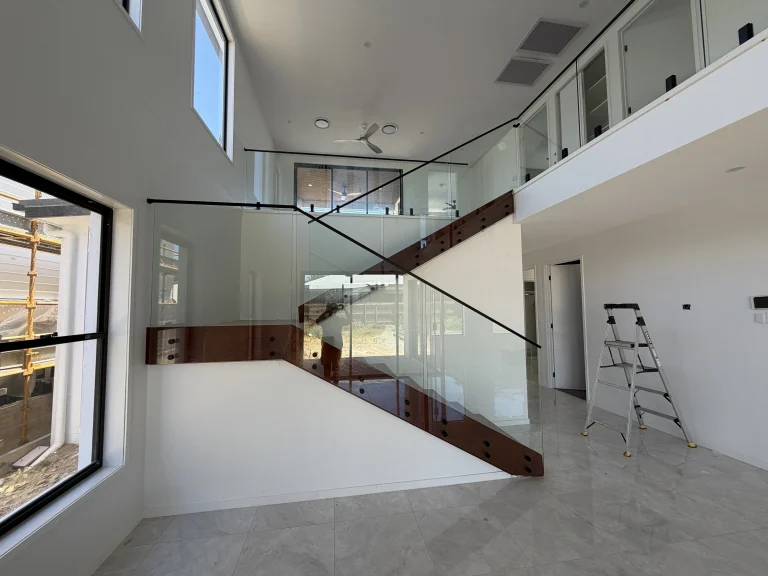 Semi-frameless glass staircase balustrade with stainless steel handrail