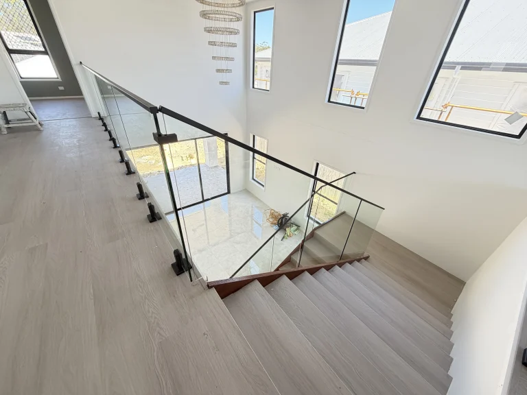 Modern frameless glass railing on an internal staircase in a Brisbane home